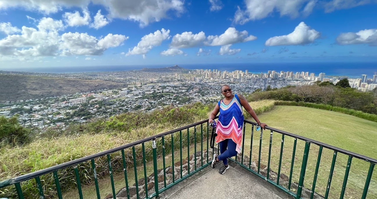 Holding my camera at Tantalus Lookout (Puu Ualakaa State Park) with the spectacular view of Honolulu behind me.