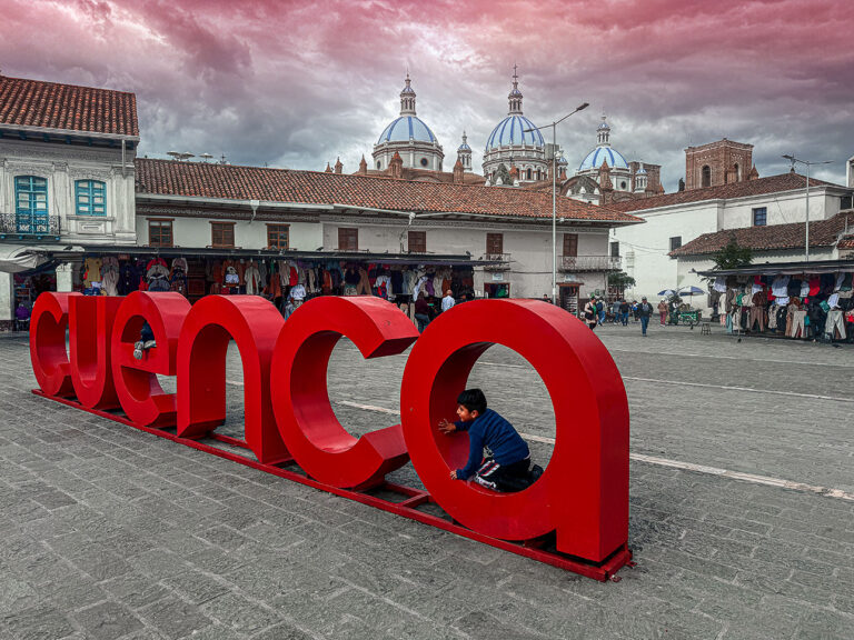 Huge letters spelling “cuenca” with a young boy crouching in the letter A. The famous Catedral de la Inmaculada Concepcion is in the background.