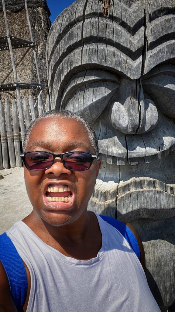 Me, channeling determination—fierce face on full display to match the Hawaiian tiki behind me.