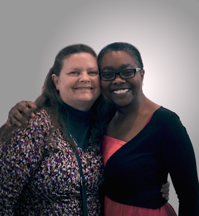 Friends smiling and hugging before their relocation plans changed—Mel will now be moving abroad alone