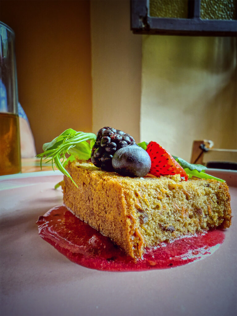 A slice of moist, berry-topped cake, bursting with fresh color and sweetness