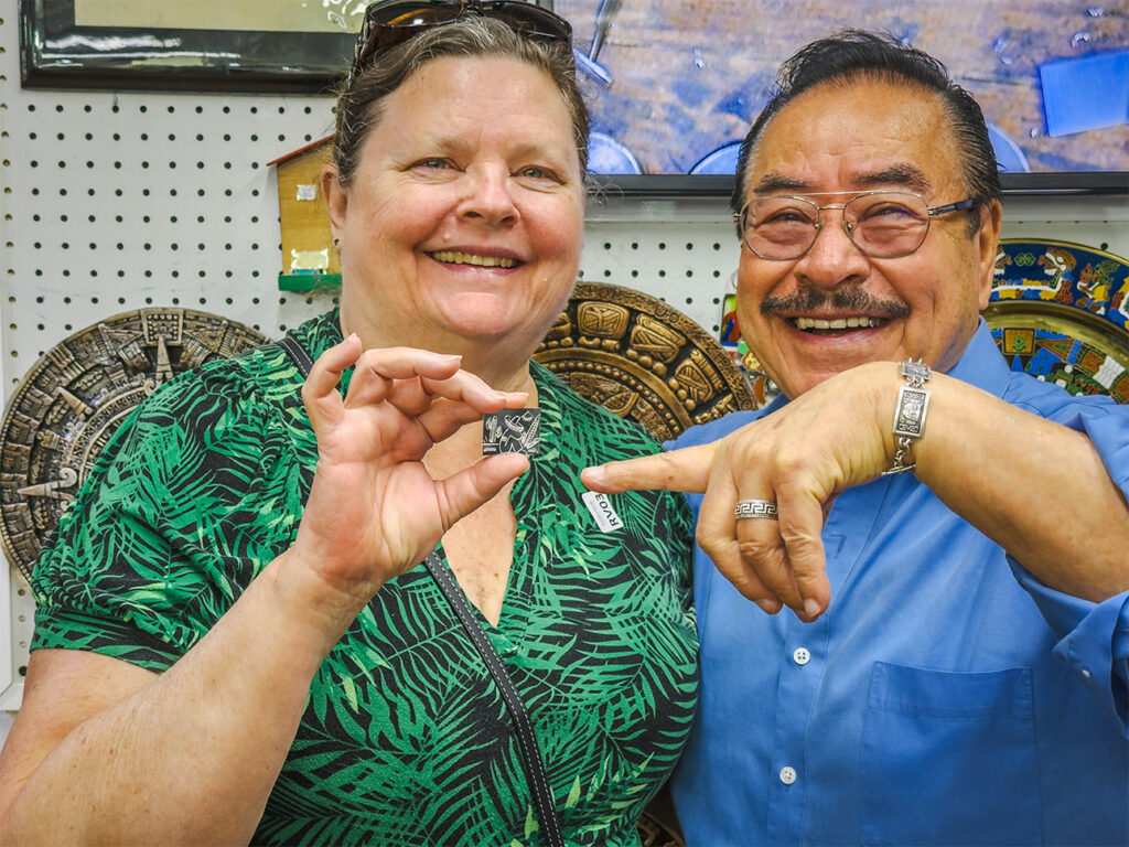 Tammi smiling with her carved tin sample from master silversmith Rafael