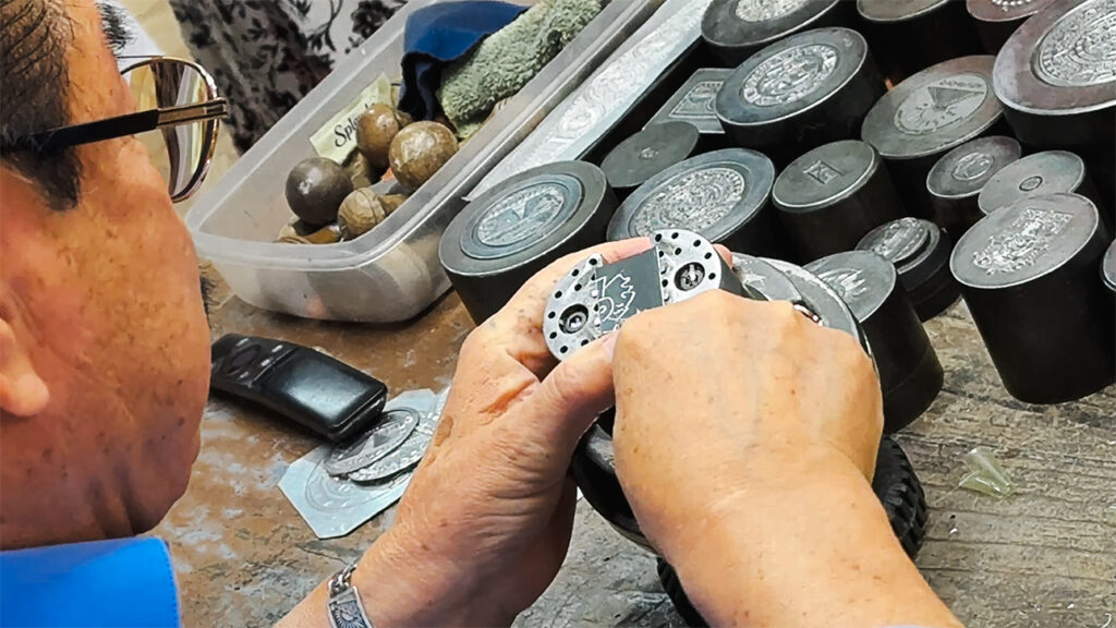Master silversmith demonstrating his technique on tin