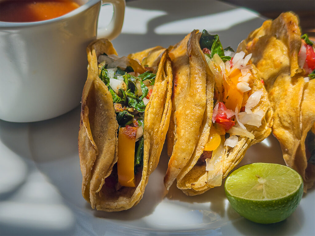 Closeup of Birria tacos enhanced with sauteed vegetables