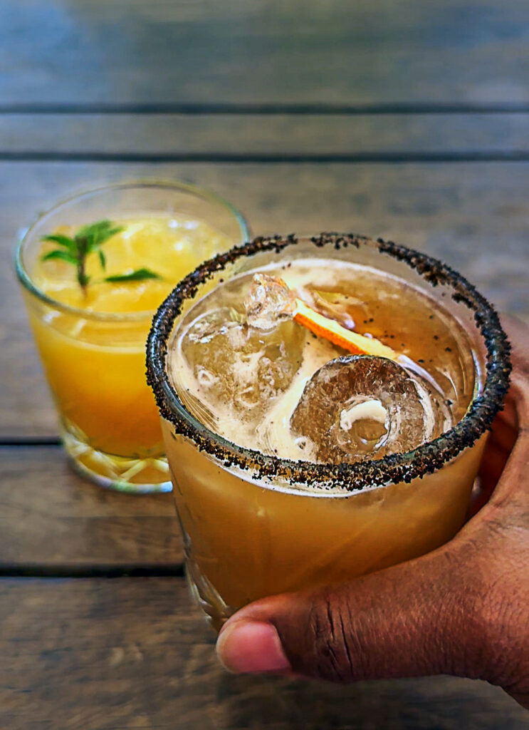 Black person's hand picking up a cocktail