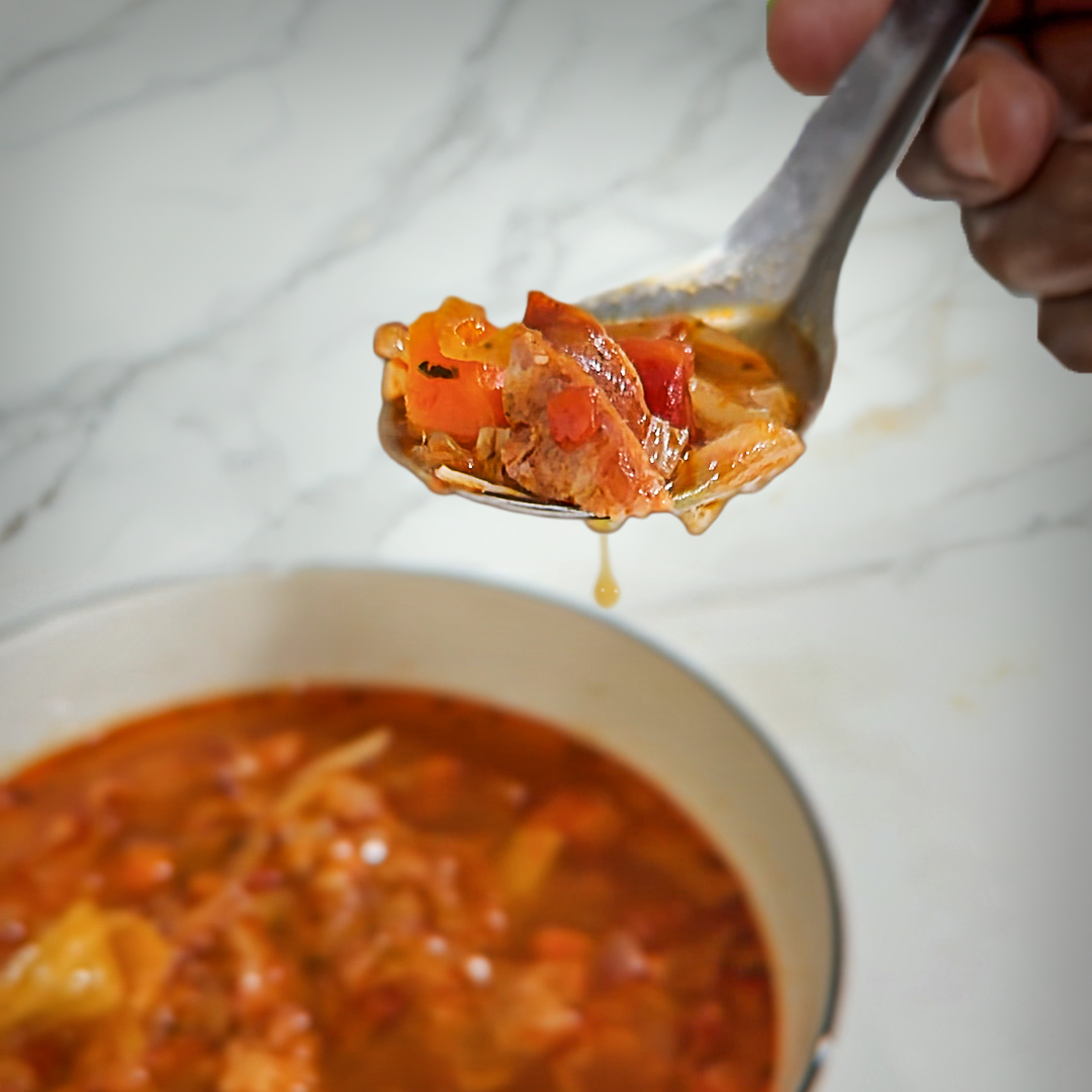 Spoonful of Thai Hot Pot Cabbage and Pork Soup  over a bowl